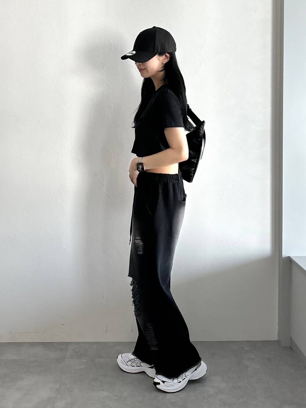 ブラック系のスウェットパンツ、ブラック系のTシャツ/カットソー、ブラック系のショルダーバッグを着用したレディースの春コーディネートの3枚目の写真