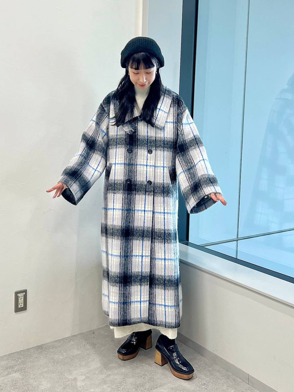 ホワイト系のステンカラーコート、ホワイト系のワンピース、ホワイト系のニット/セーターを着用したレディースの秋コーディネートの2枚目の写真