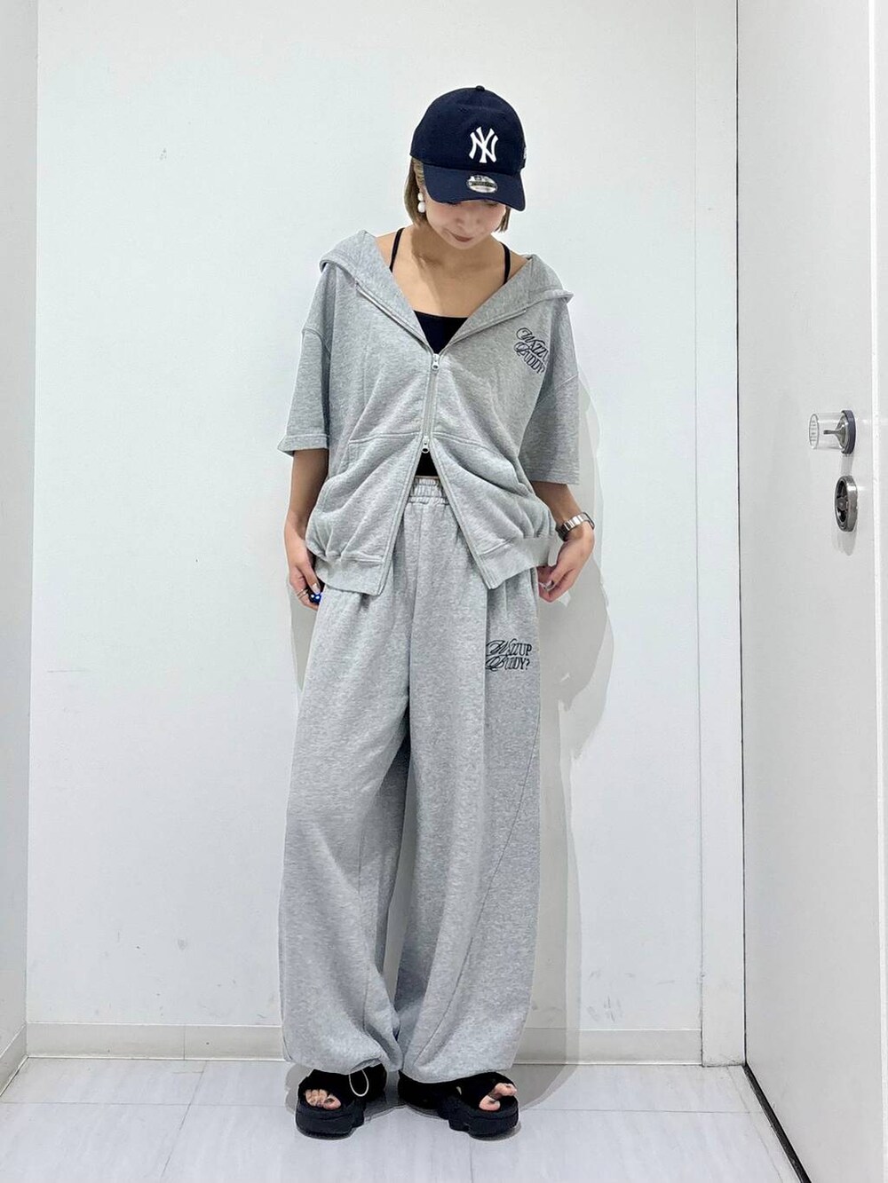 グレー系のスウェットパンツ、グレー系のパーカー、ブルー系のキャップを着用したレディースの夏コーディネートの2枚目の写真