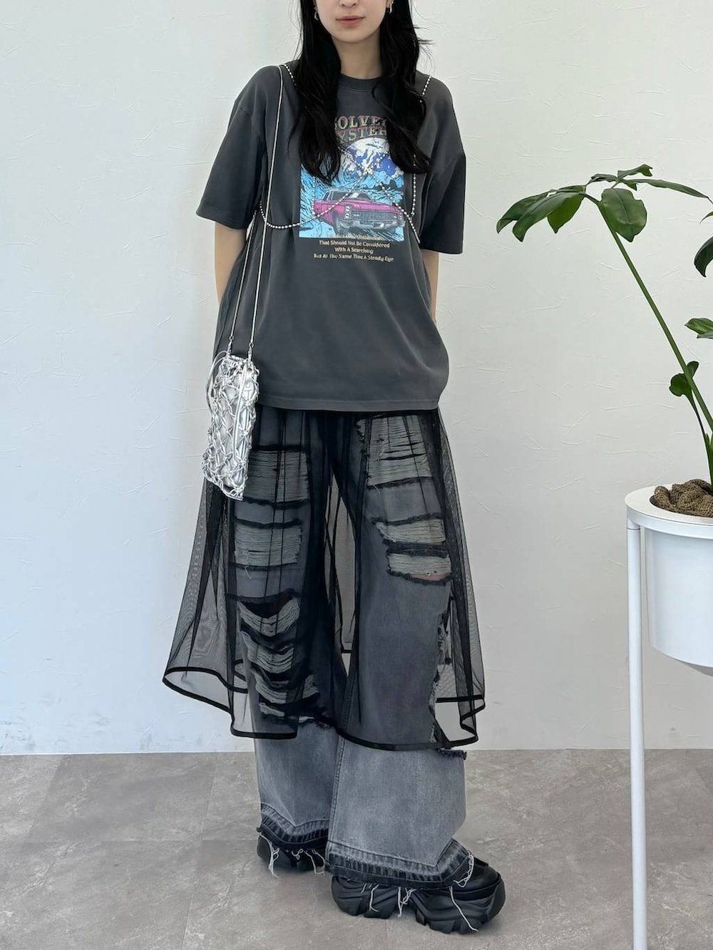 ブラック系のデニムパンツ、グレー系のTシャツ/カットソー、シルバー系のショルダーバッグを着用したレディースの春コーディネートの3枚目の写真