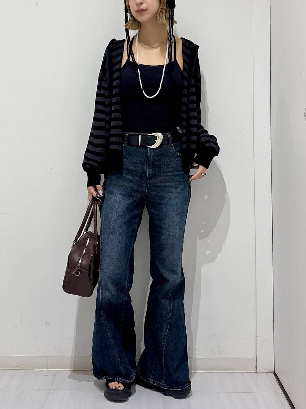 ブラック系のキャミソール、ブラウン系のショルダーバッグ、ブルー系のデニムパンツを着用したレディースの夏コーディネートの5枚目の写真