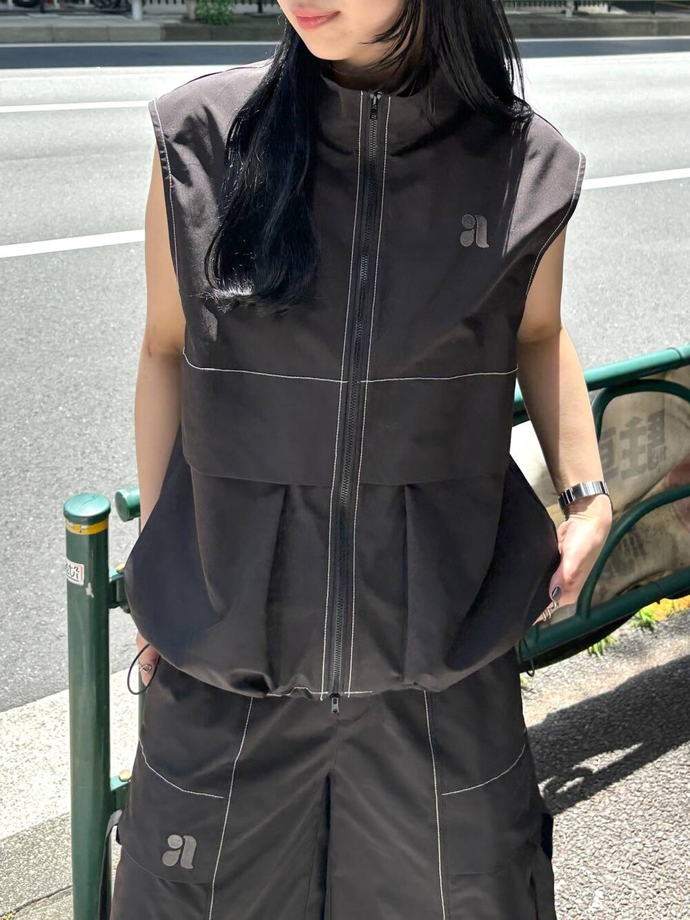 ブラック系のベスト、ブラック系のカーゴパンツを着用したレディースの夏コーディネートの3枚目の写真