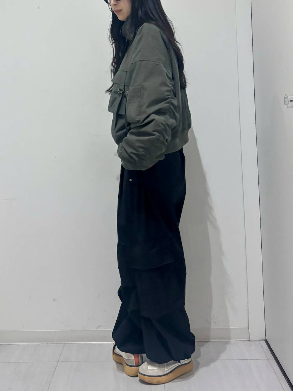 グリーン系のブルゾン、ブラック系のカーゴパンツを着用したレディースの秋コーディネートの3枚目の写真