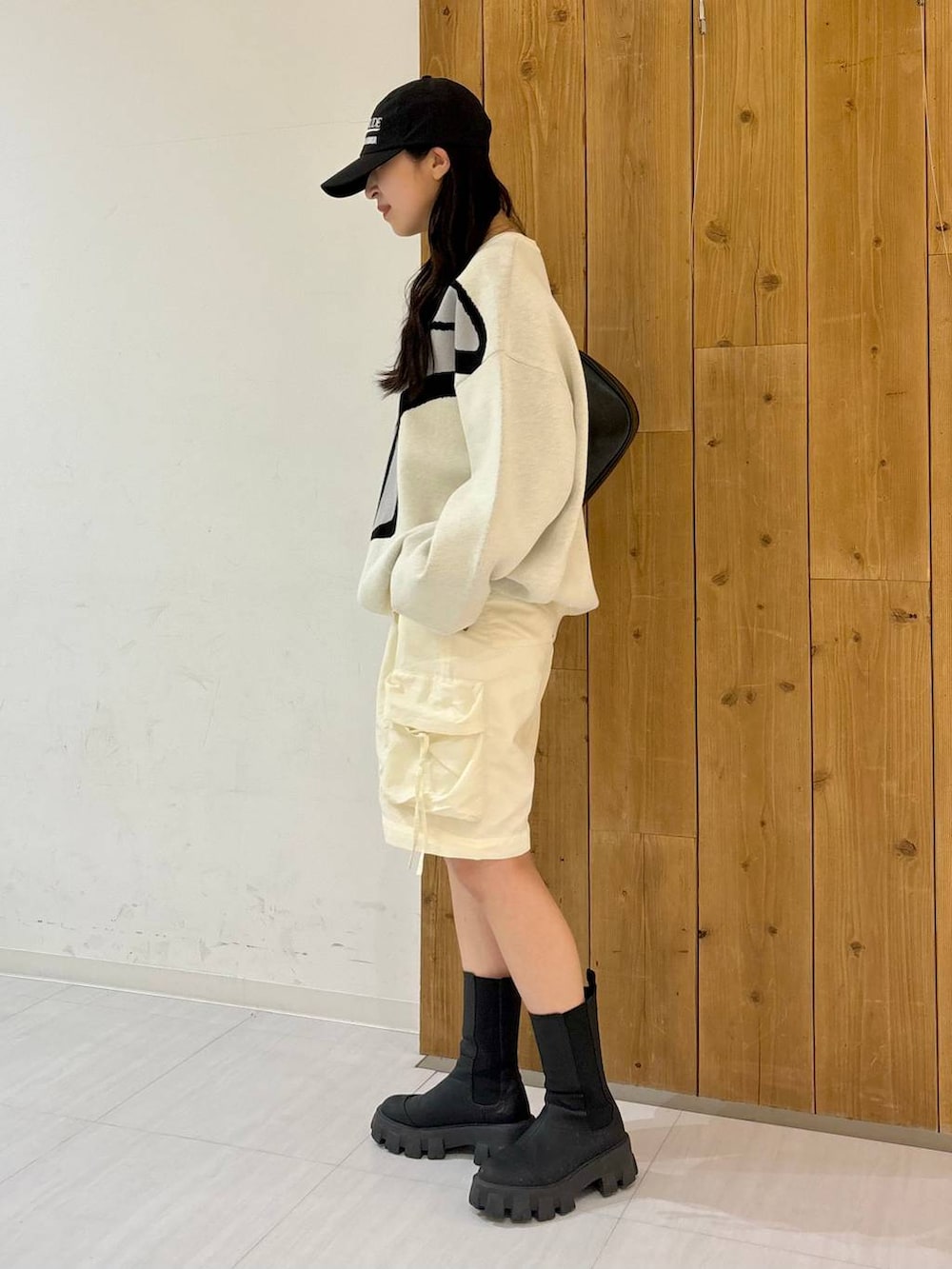 ホワイト系のカーゴパンツ、ブラック系のブーツ、ブラック系のショルダーバッグを着用したレディースの冬コーディネートの3枚目の写真