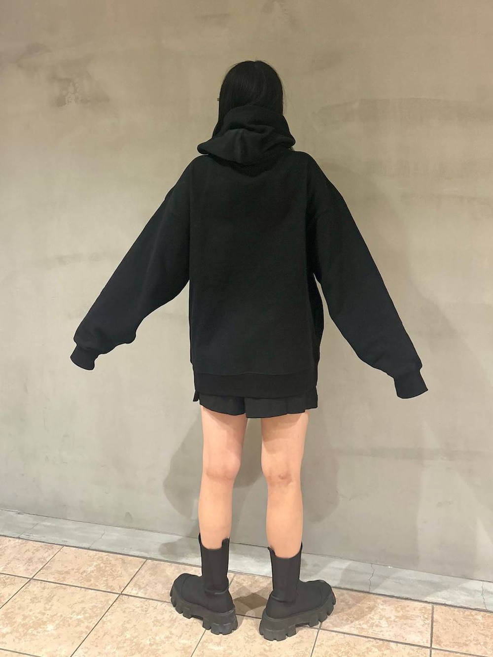 ブラック系のパーカー、ブラック系のブーツ、ブラック系のその他パンツを着用したレディースの冬コーディネートの4枚目の写真