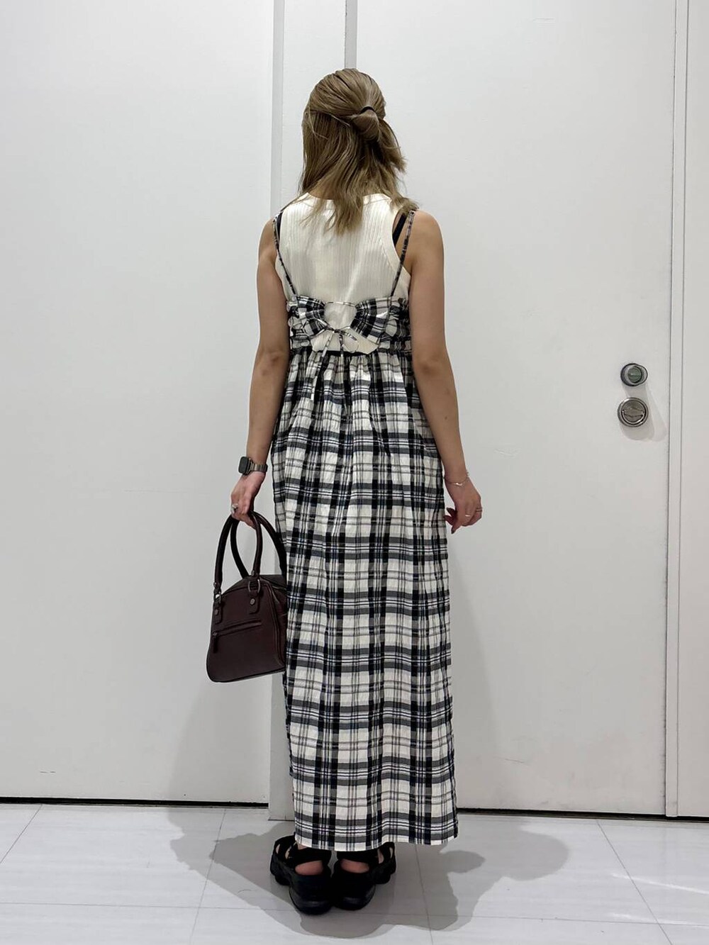 ホワイト系のタンクトップ、ブラウン系のショルダーバッグ、ホワイト系のワンピースを着用したレディースの夏コーディネートの5枚目の写真