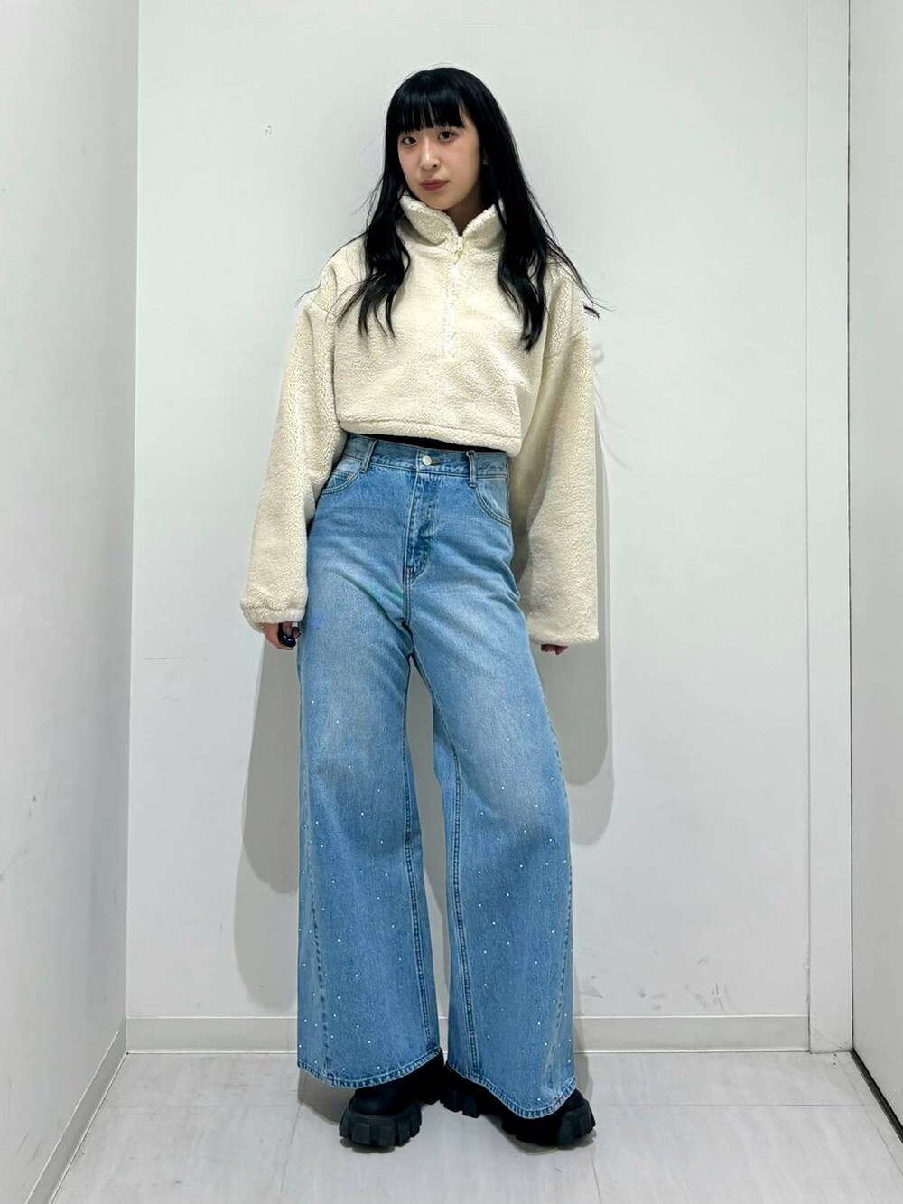 ブラック系のブーツ、ホワイト系のその他アウター、ブルー系のデニムパンツを着用したレディースの冬コーディネートの4枚目の写真