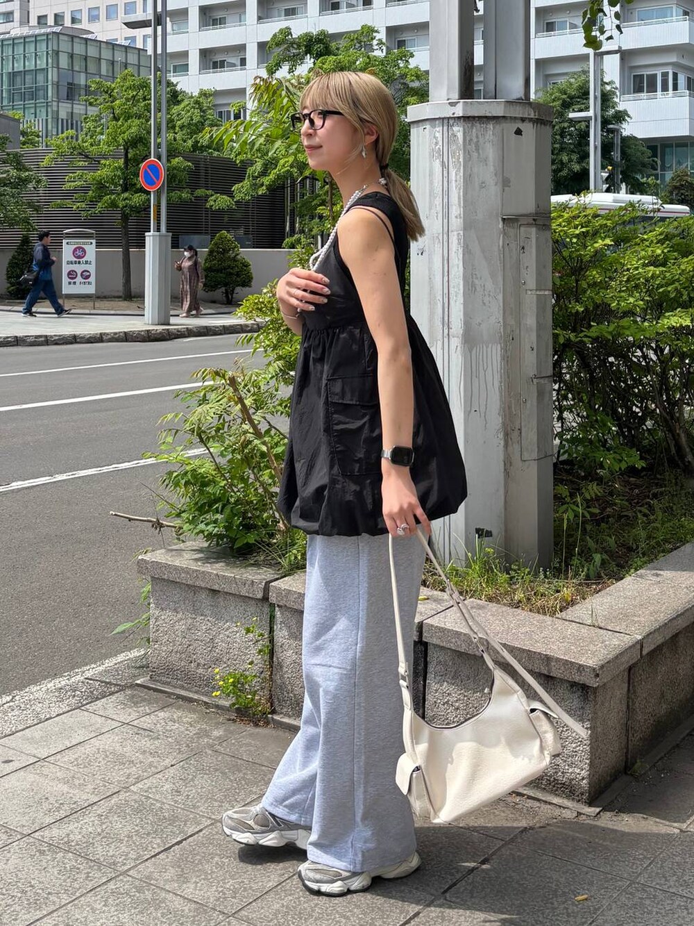 ブラック系のタンクトップ、ホワイト系のショルダーバッグ、グレー系のスウェットパンツを着用したレディースの夏コーディネートの4枚目の写真