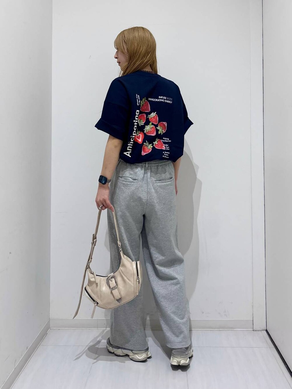 ホワイト系のショルダーバッグ、ブルー系のTシャツ/カットソー、グレー系のスウェットパンツを着用したレディースの春コーディネートの4枚目の写真