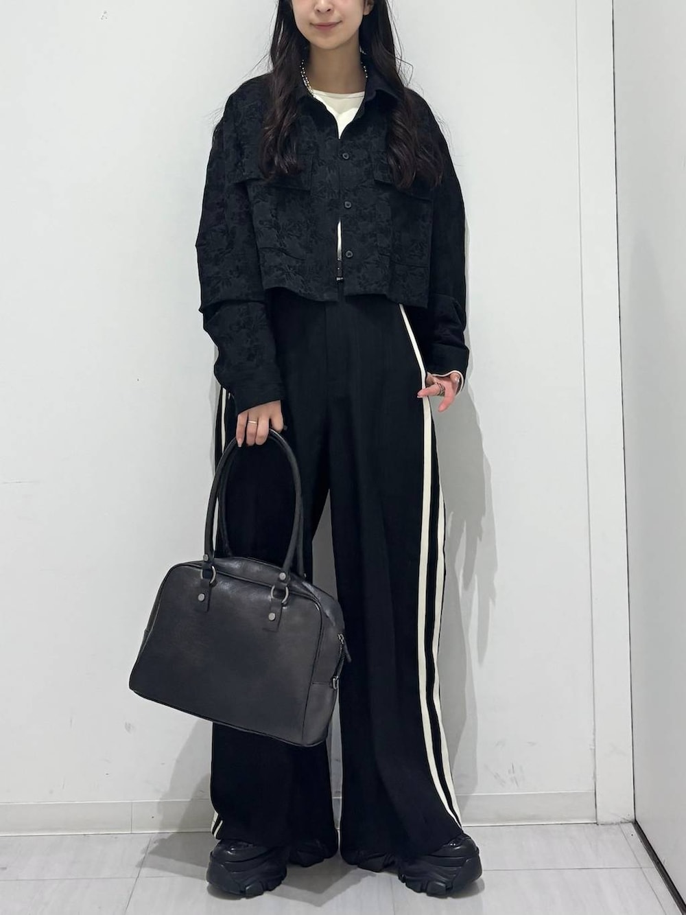 ブラック系のスニーカー、ブラック系のシャツ/ブラウス、グレー系のTシャツ/カットソーを着用したレディースの冬コーディネートの6枚目の写真