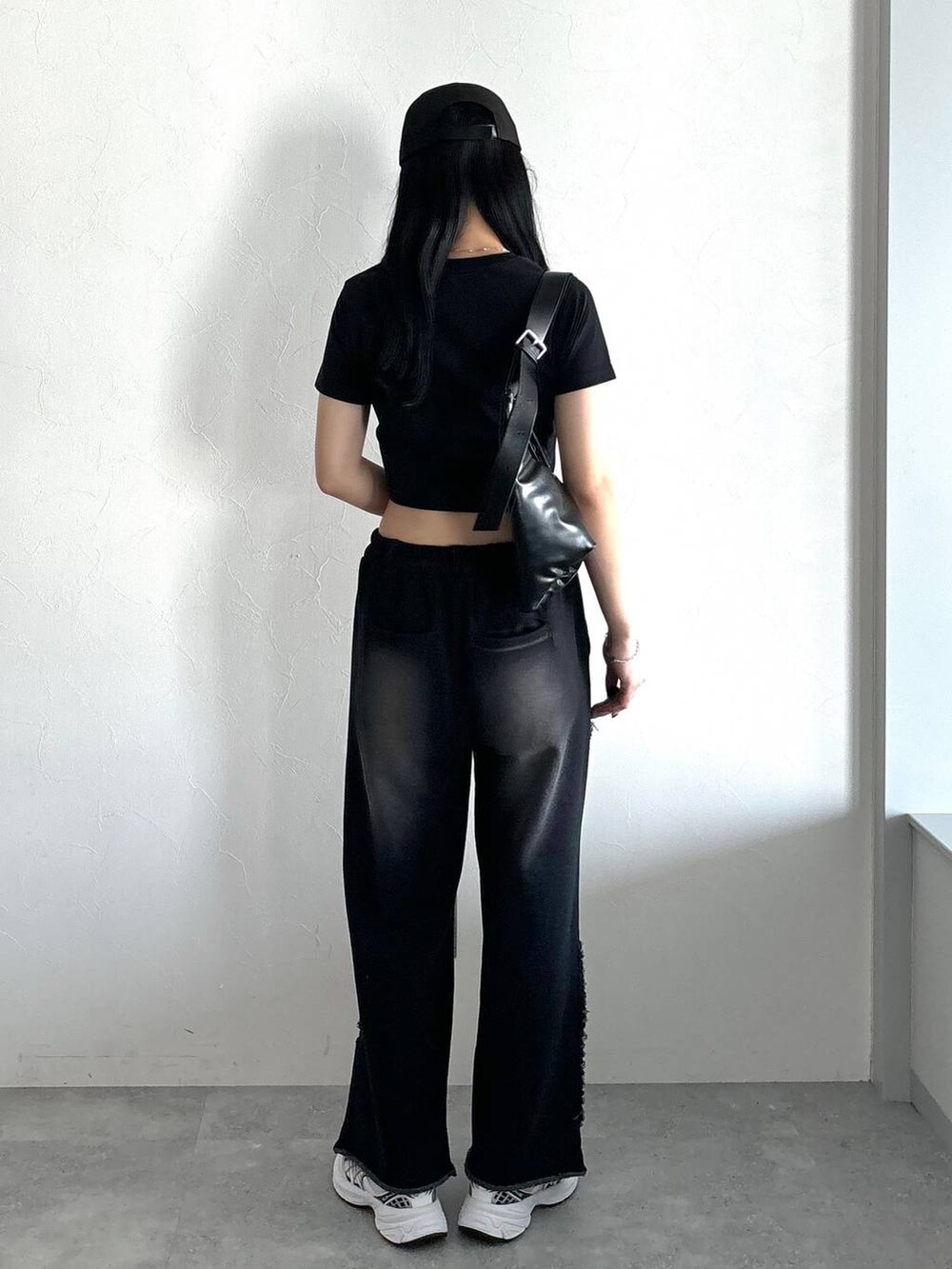 ブラック系のスウェットパンツ、ブラック系のTシャツ/カットソー、ブラック系のショルダーバッグを着用したレディースの春コーディネートの5枚目の写真