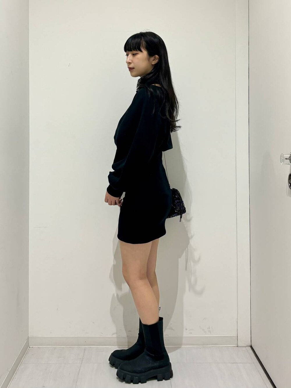 ブラック系のワンピース、ブラック系のブーツ、ブラック系のショルダーバッグを着用したレディースの冬コーディネートの3枚目の写真