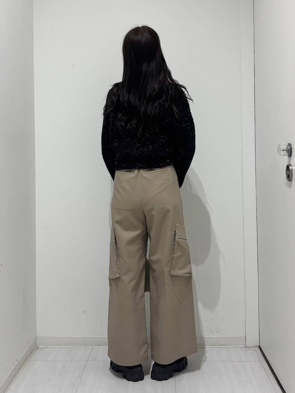 ホワイト系のショルダーバッグ、ベージュ系のカーゴパンツ、ブラック系のカーディガン/ボレロを着用したレディースの冬コーディネートの3枚目の写真