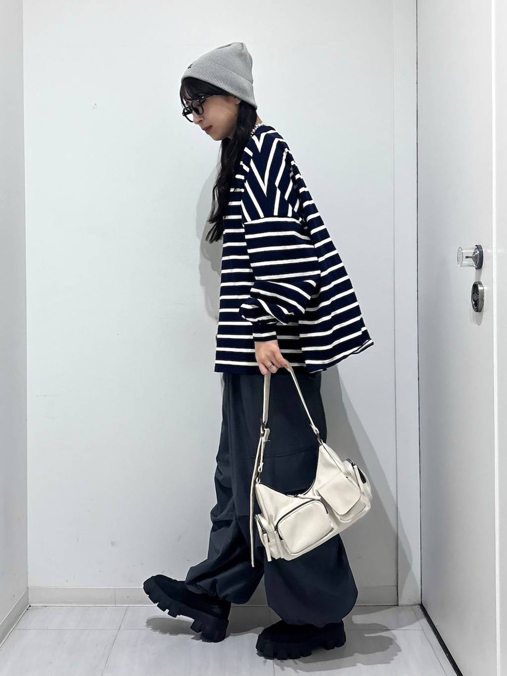 ホワイト系のショルダーバッグ、ブルー系のTシャツ/カットソー、グレー系のカーゴパンツを着用したレディースの冬コーディネートの3枚目の写真