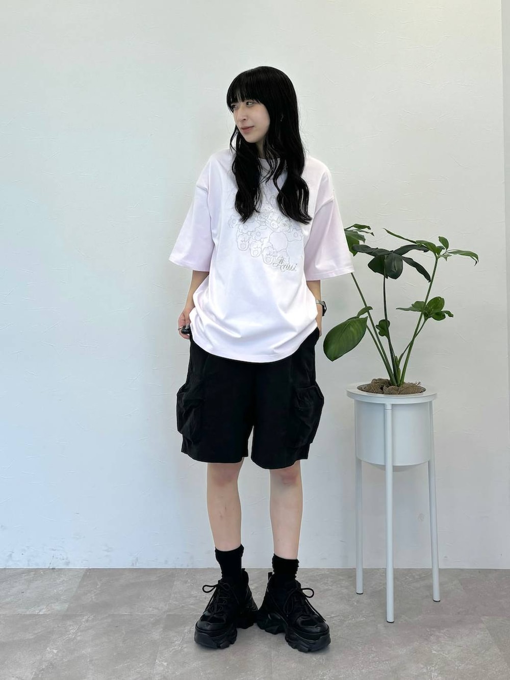 ブラック系のスニーカー、ブラック系のカーゴパンツ、ホワイト系のTシャツ/カットソーを着用したレディースの春コーディネートの5枚目の写真