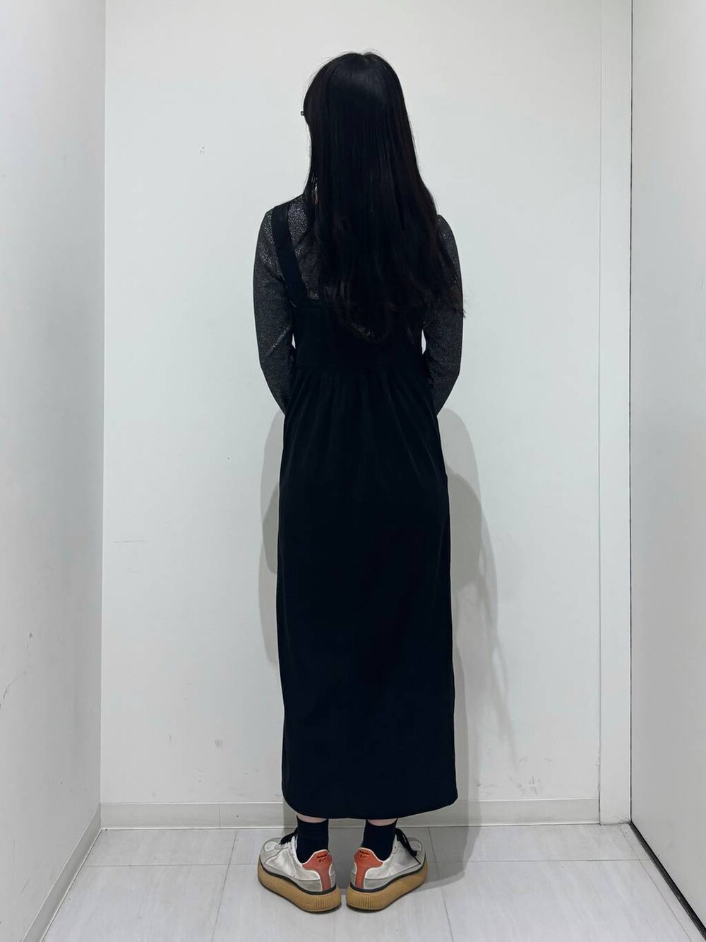 シルバー系のショルダーバッグ、シルバー系のTシャツ/カットソー、ブラック系のワンピースを着用したレディースの秋コーディネートの4枚目の写真