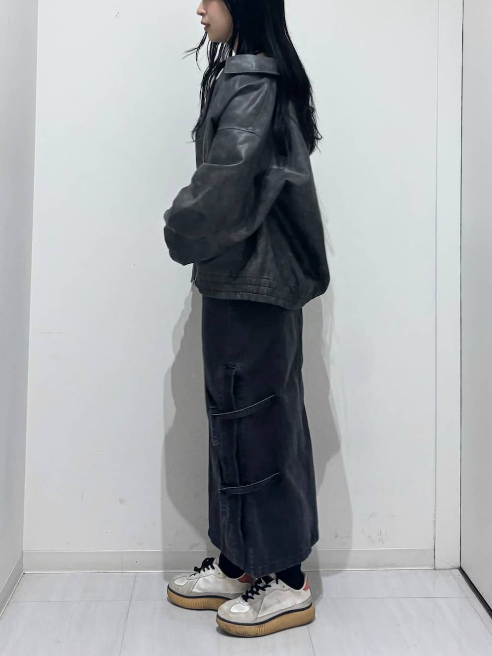 ブラック系のブルゾン、ブラック系のデニムスカート、ブラック系のニット/セーターを着用したレディースの秋コーディネートの2枚目の写真
