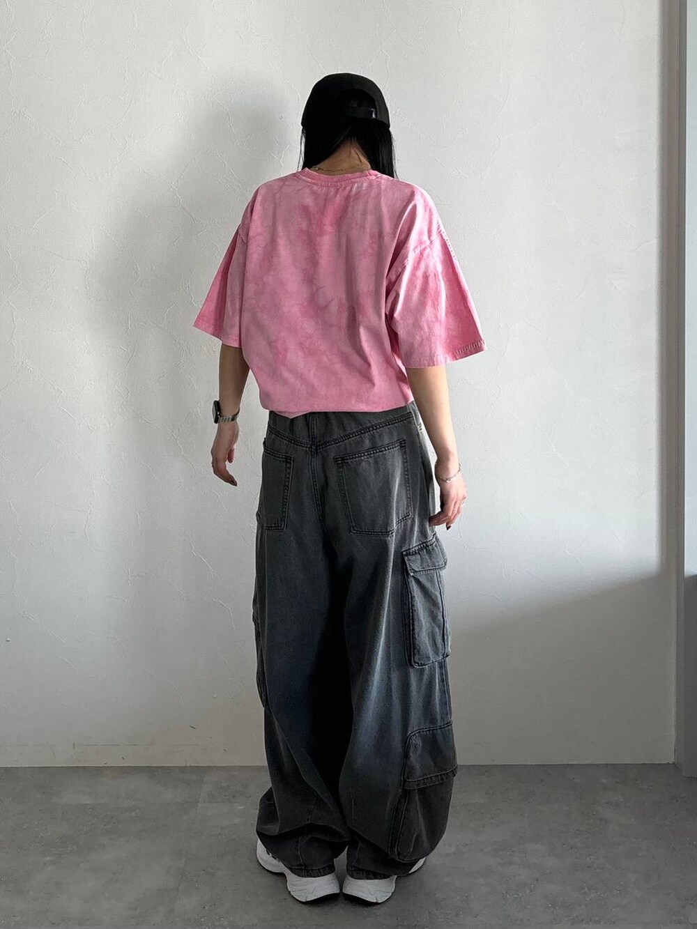 ピンク系のTシャツ/カットソー、ブラック系のデニムパンツを着用したレディースの春コーディネートの4枚目の写真