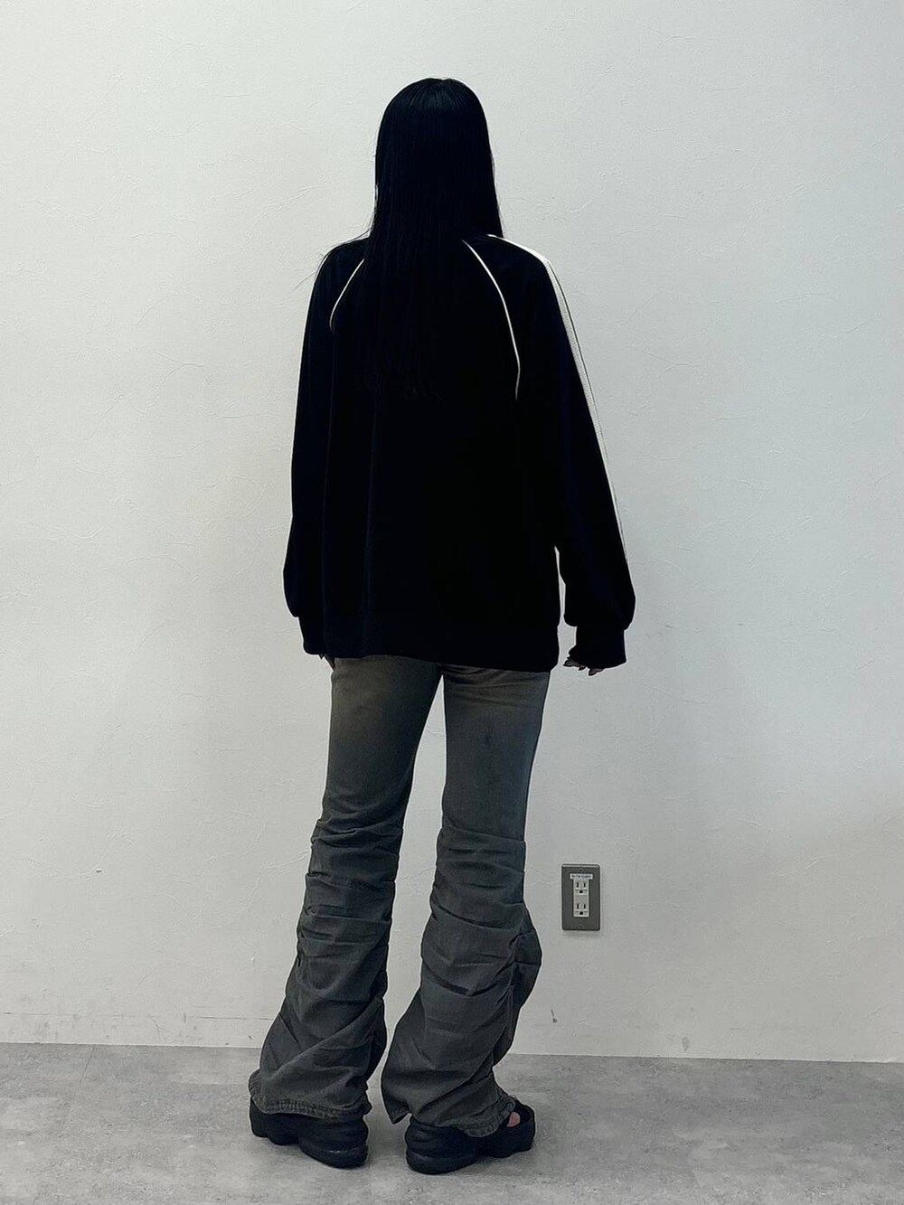 ブルー系のデニムパンツ、ブラック系のジャージを着用したレディースの秋コーディネートの4枚目の写真