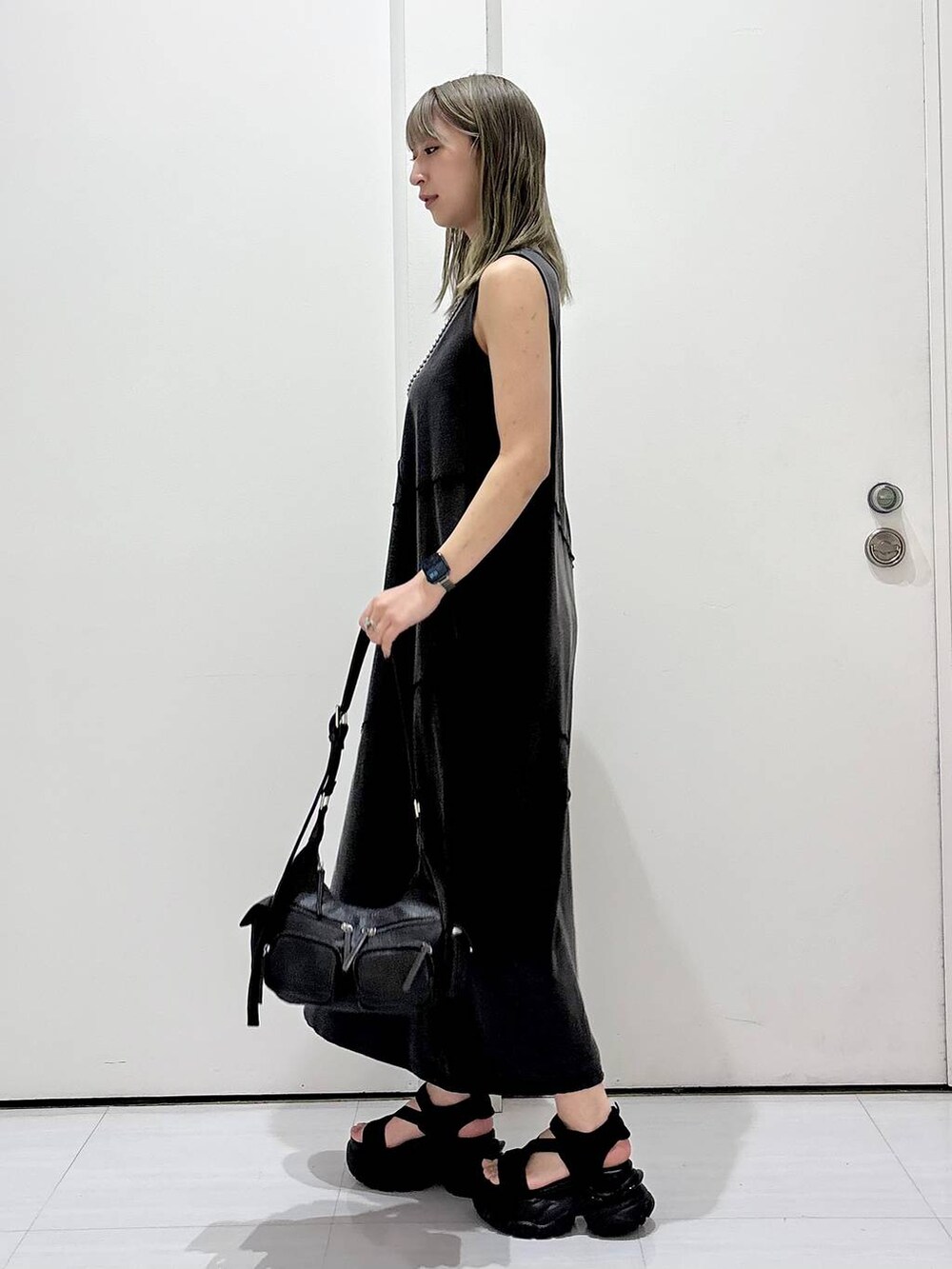 ブラック系のサンダル、ブラック系のワンピース、ブラック系のショルダーバッグを着用したレディースの春コーディネートの5枚目の写真