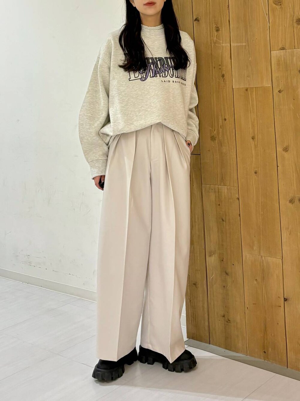 ブラック系のブーツ、ベージュ系のスラックス、ベージュ系のスウェットを着用したレディースの冬コーディネートの2枚目の写真