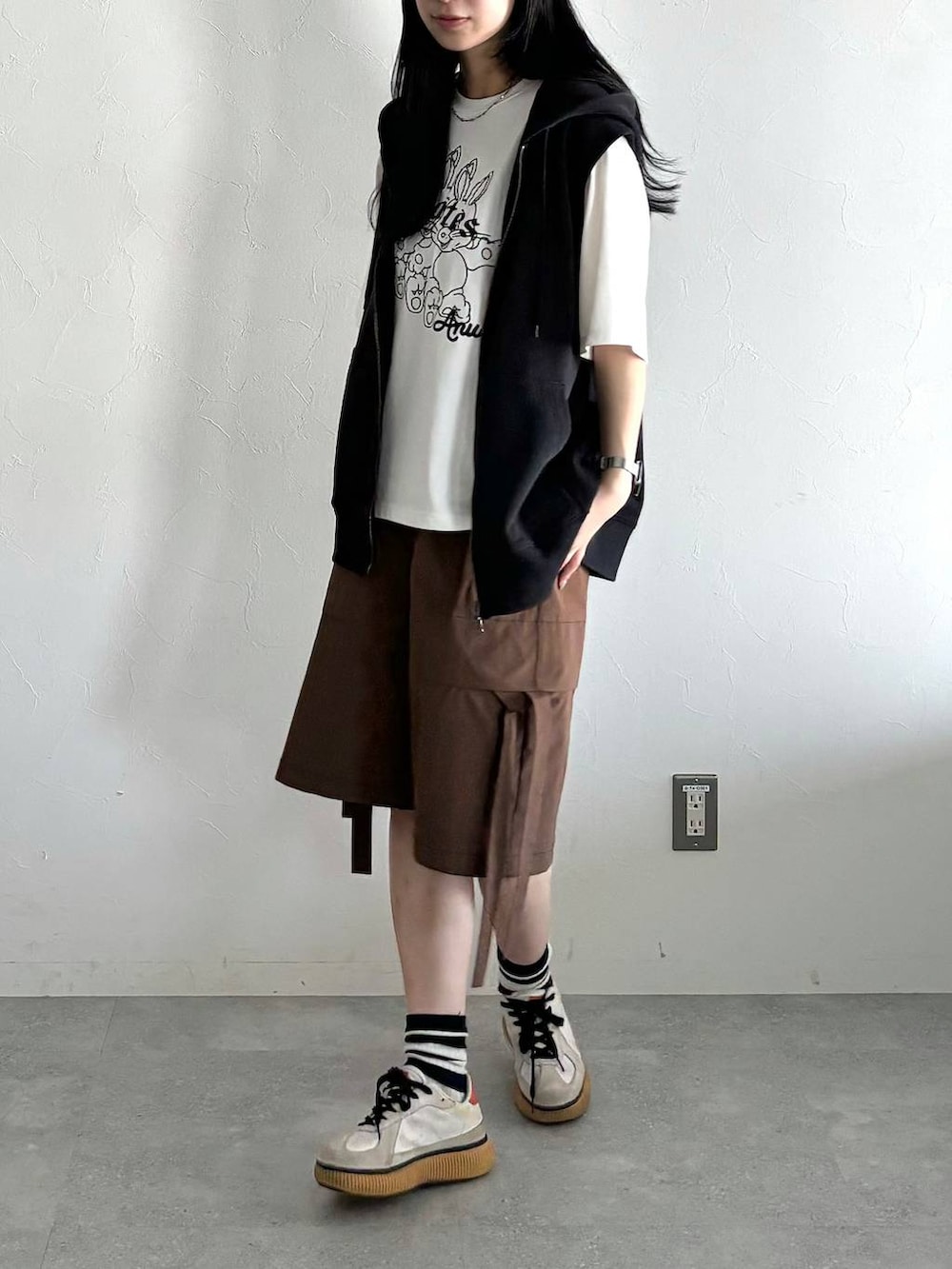 ブラック系のパーカー、ホワイト系のTシャツ/カットソー、ブラウン系のカーゴパンツを着用したレディースの夏コーディネートの2枚目の写真