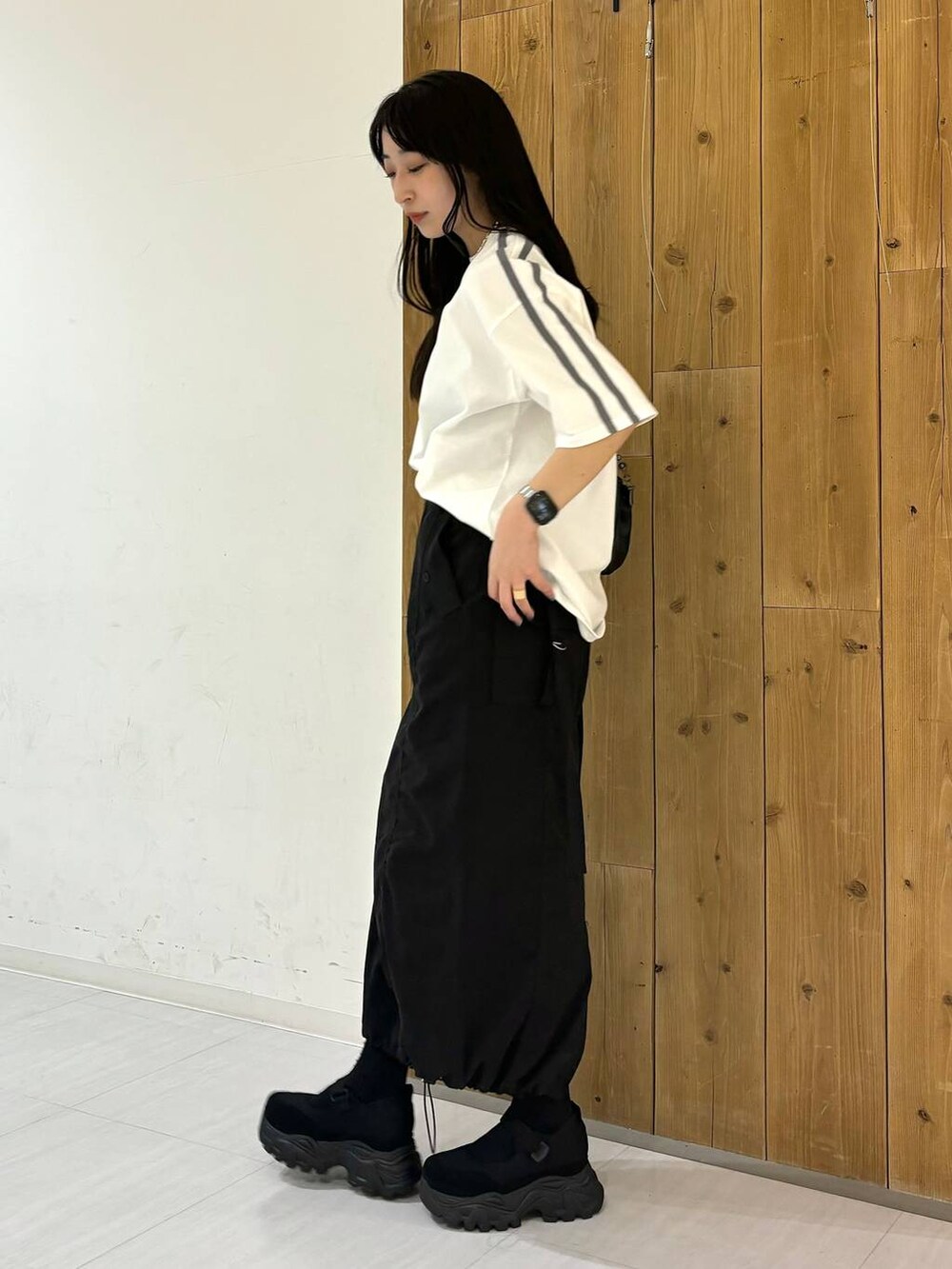 ブラック系のショルダーバッグ、ホワイト系のTシャツ/カットソー、ブラック系のスニーカーを着用したレディースの春コーディネートの3枚目の写真