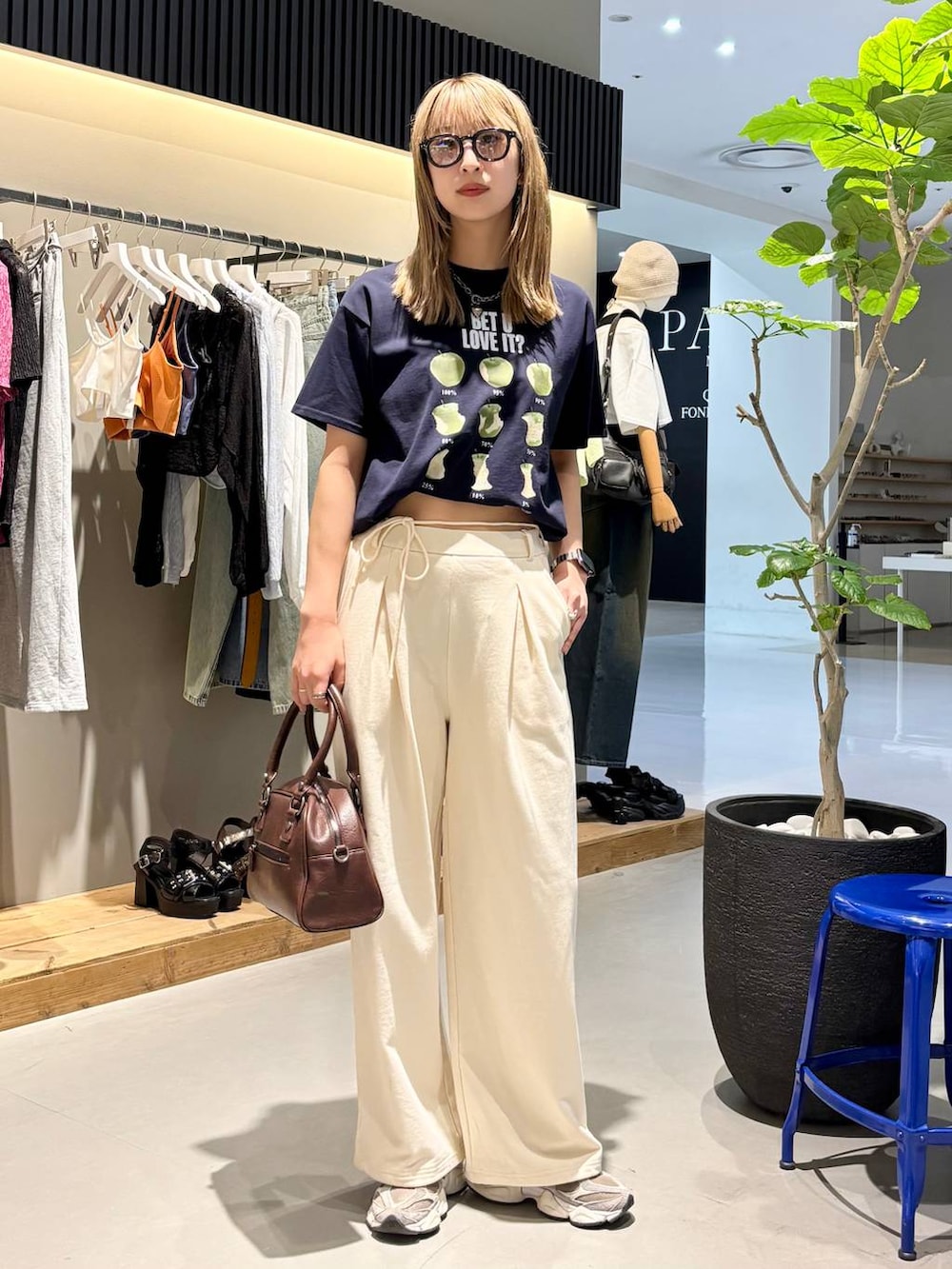 ブルー系のTシャツ/カットソー、ブラウン系のショルダーバッグ、ホワイト系のスウェットパンツを着用したレディースの夏コーディネートの6枚目の写真