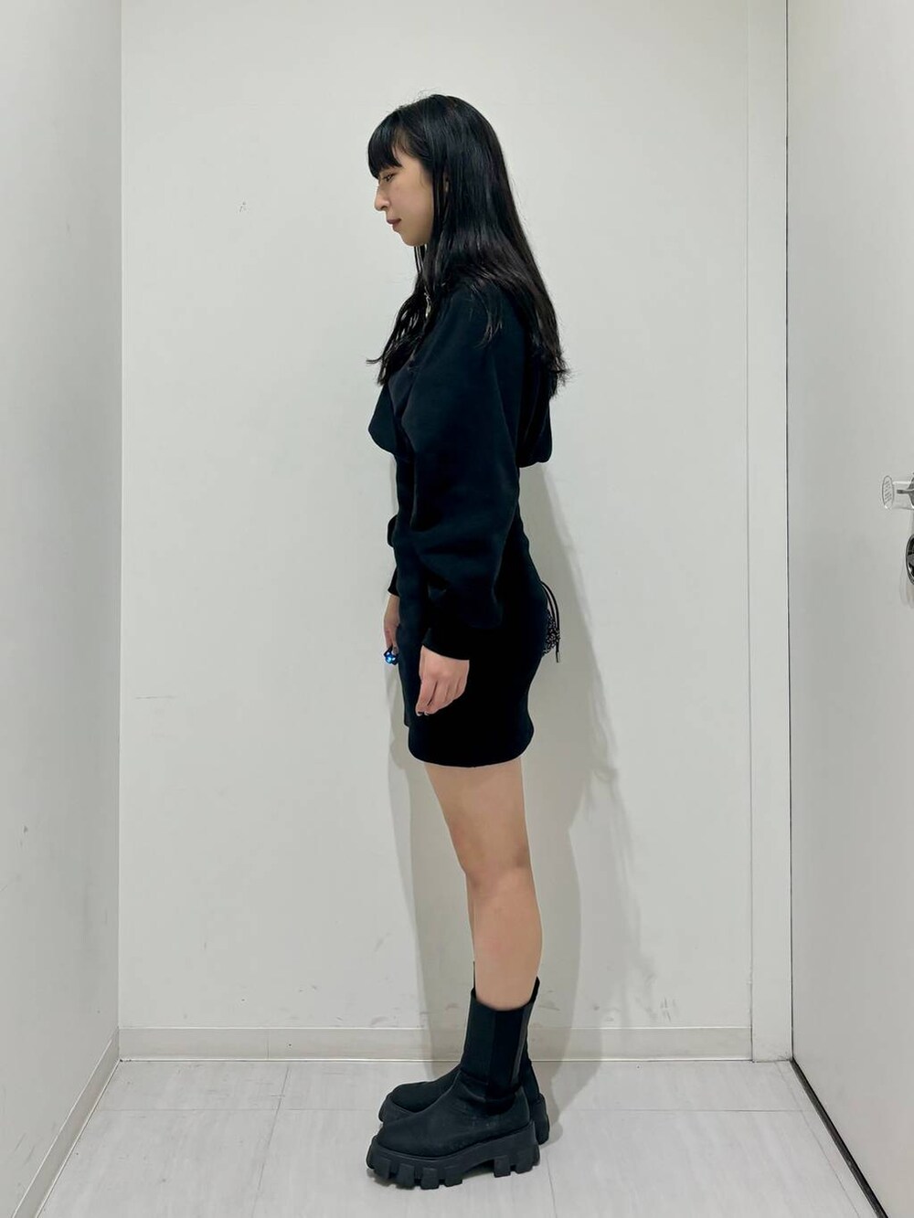 ブラック系のワンピース、ブラック系のブーツ、ブラック系のショルダーバッグを着用したレディースの冬コーディネートの4枚目の写真