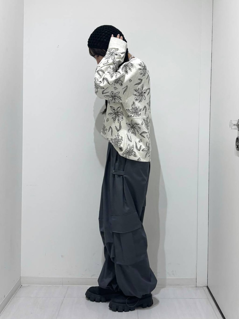 グレー系のカーゴパンツ、グレー系のスウェット、ブラック系のニットキャップ/ビーニーを着用したレディースの冬コーディネートの3枚目の写真