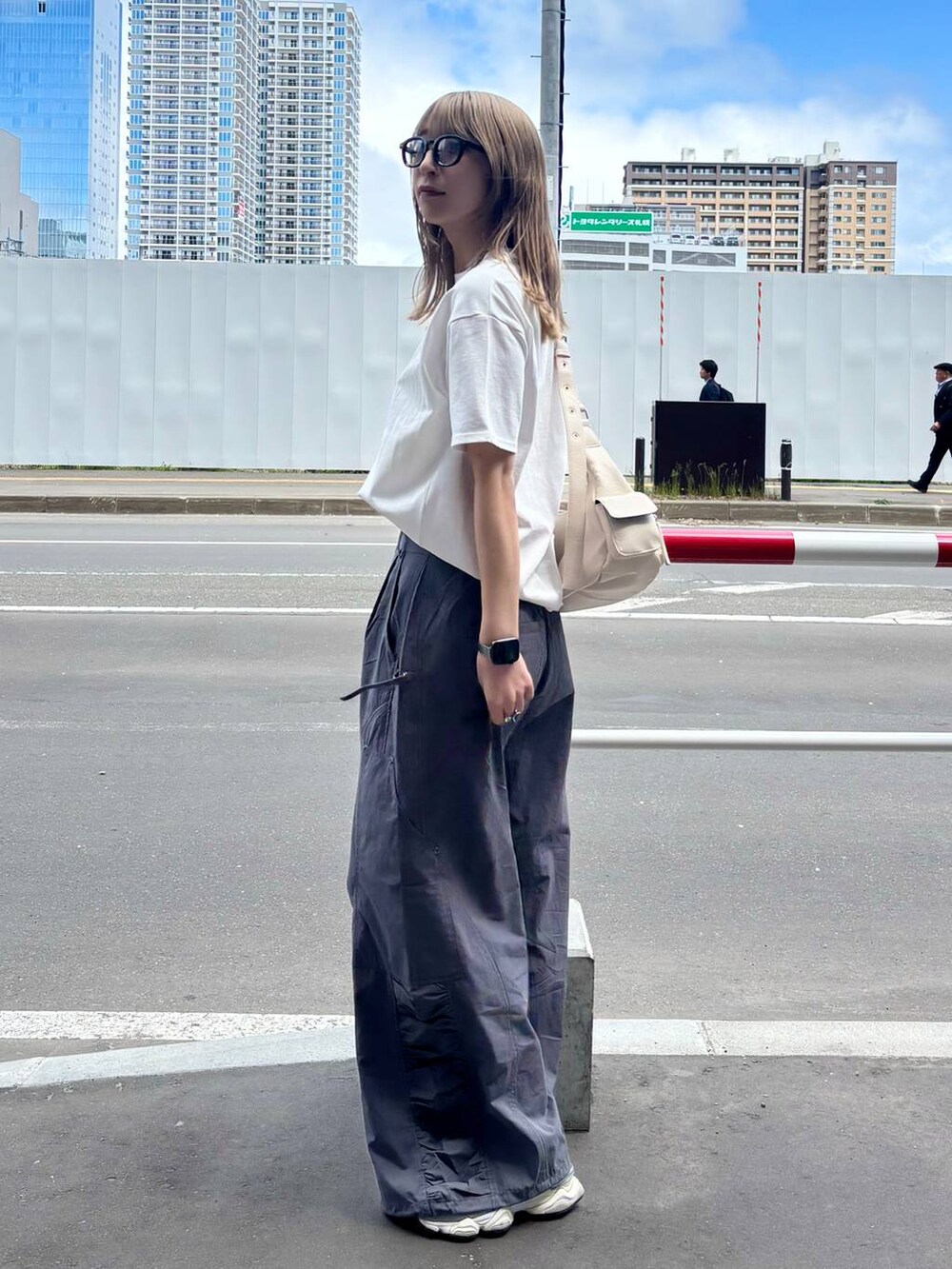 ホワイト系のショルダーバッグ、ホワイト系のTシャツ/カットソー、グレー系のカーゴパンツを着用したレディースの夏コーディネートの3枚目の写真