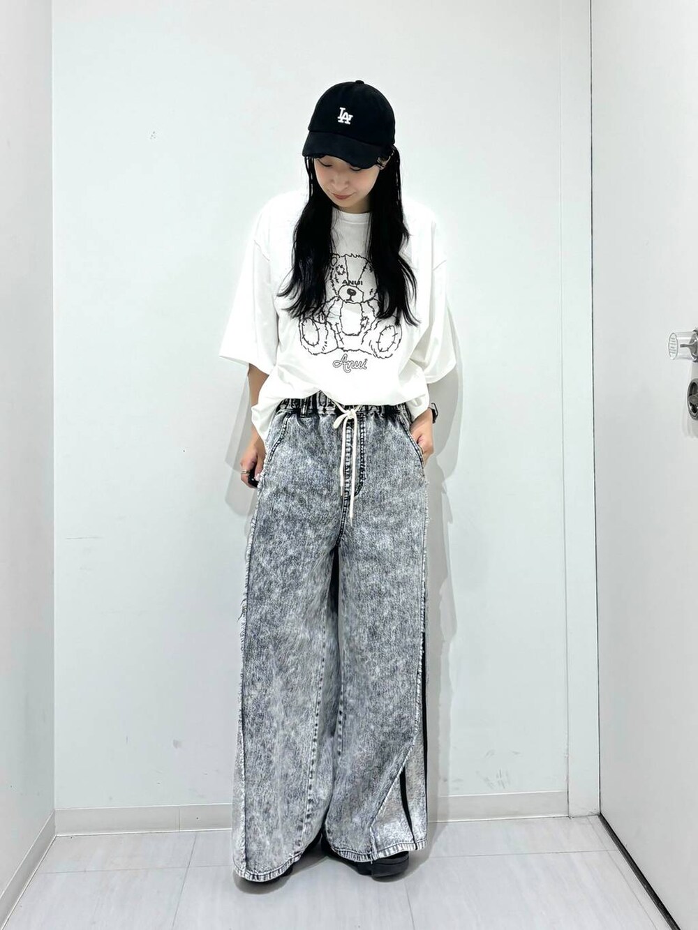 ホワイト系のTシャツ/カットソー、グレー系のデニムパンツ、ブラック系のキャップを着用したレディースの夏コーディネートの2枚目の写真