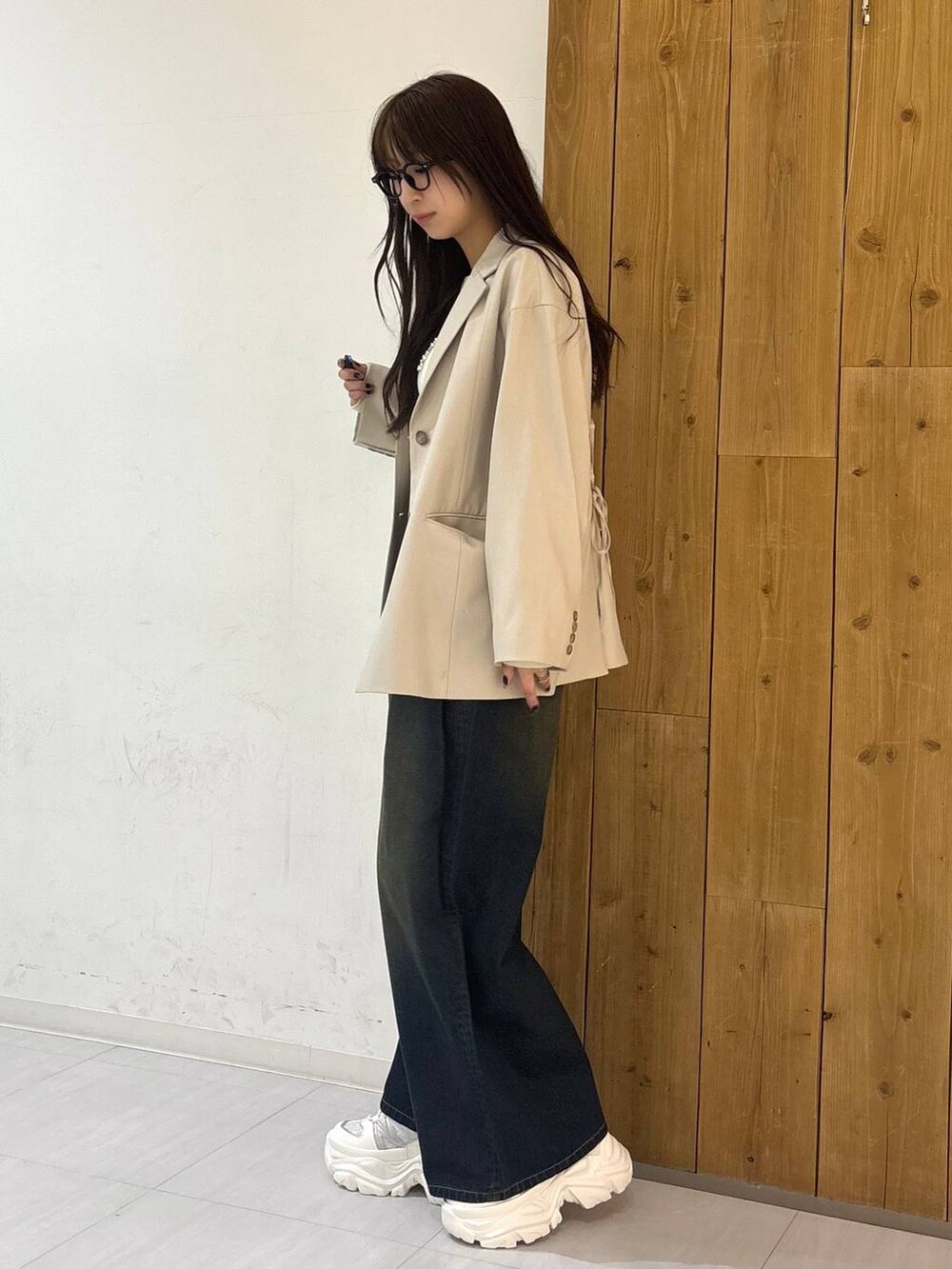 ホワイト系のスニーカー、ブルー系のデニムパンツ、ホワイト系のTシャツ/カットソーを着用したレディースの冬コーディネートの3枚目の写真