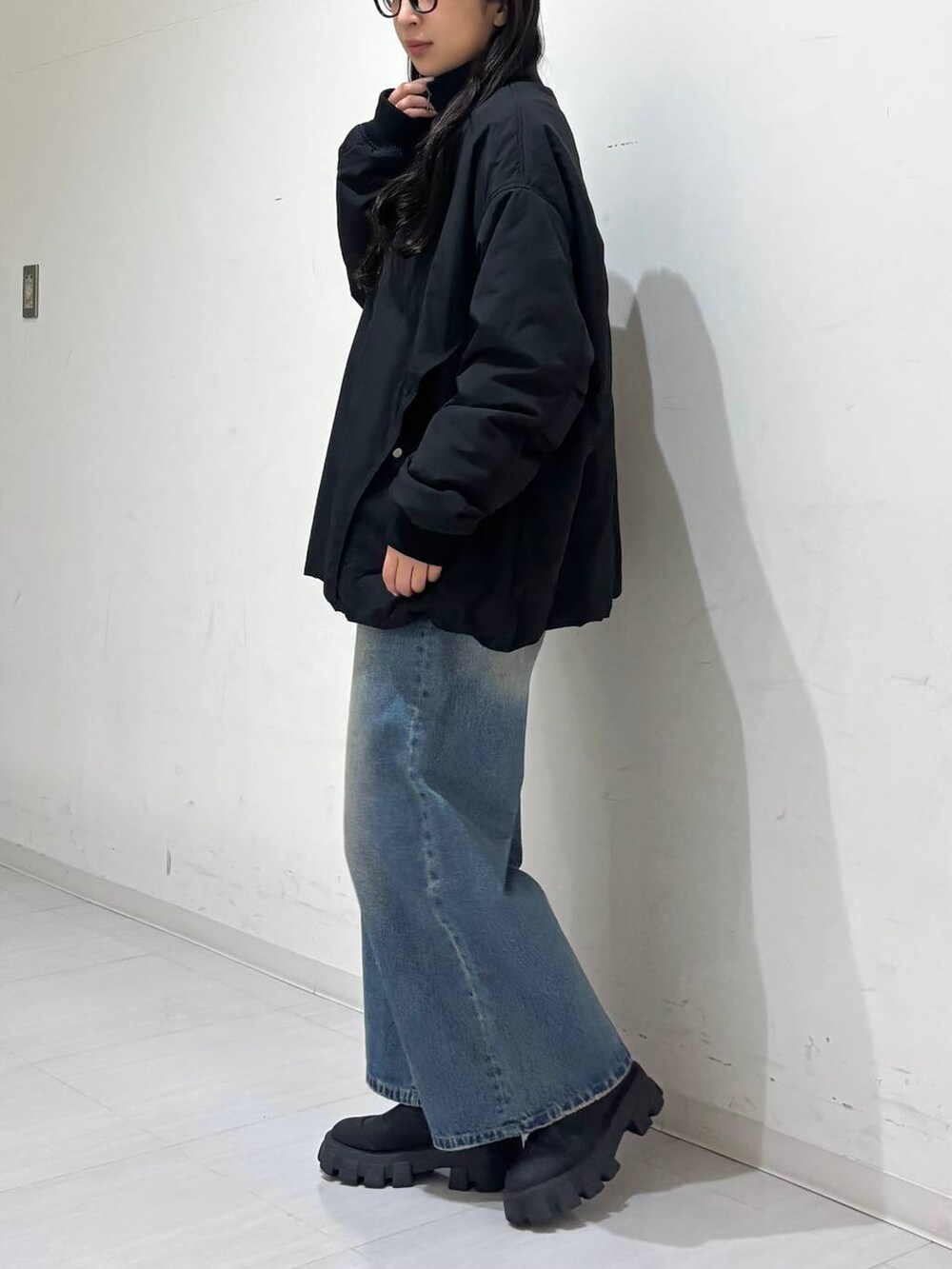 ブラック系のMA-1、ブルー系のデニムパンツを着用したレディースの冬コーディネートの2枚目の写真