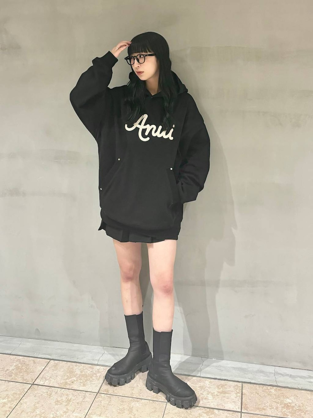 ブラック系のパーカー、ブラック系のブーツ、ブラック系のその他パンツを着用したレディースの冬コーディネートの2枚目の写真