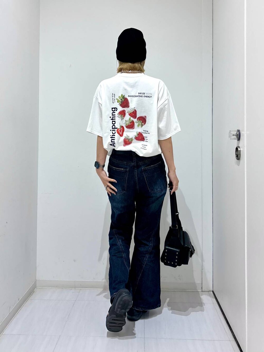 ホワイト系のTシャツ/カットソー、ブルー系のデニムパンツ、ブラック系のショルダーバッグを着用したレディースの夏コーディネートの2枚目の写真