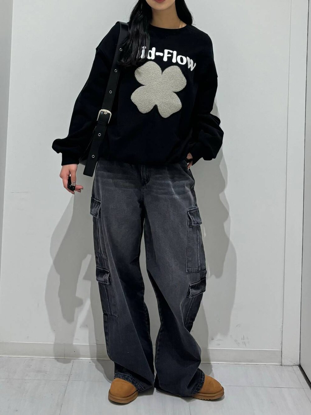 ブラック系のスウェット、ブラック系のショルダーバッグ、ブラック系のデニムパンツを着用したレディースの冬コーディネートの4枚目の写真