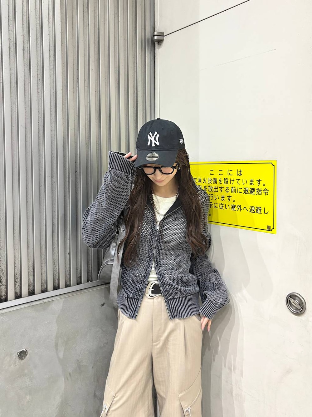 ブラック系のニット/セーター、ベージュ系のカーゴパンツ、グレー系のショルダーバッグを着用したレディースの春コーディネートの2枚目の写真