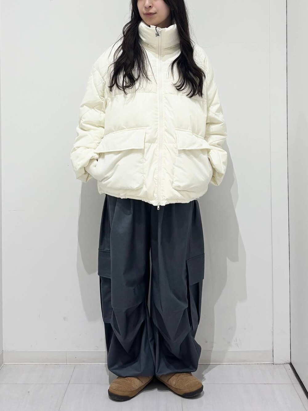 ホワイト系のブルゾン、グレー系のカーゴパンツを着用したレディースの冬コーディネートの2枚目の写真
