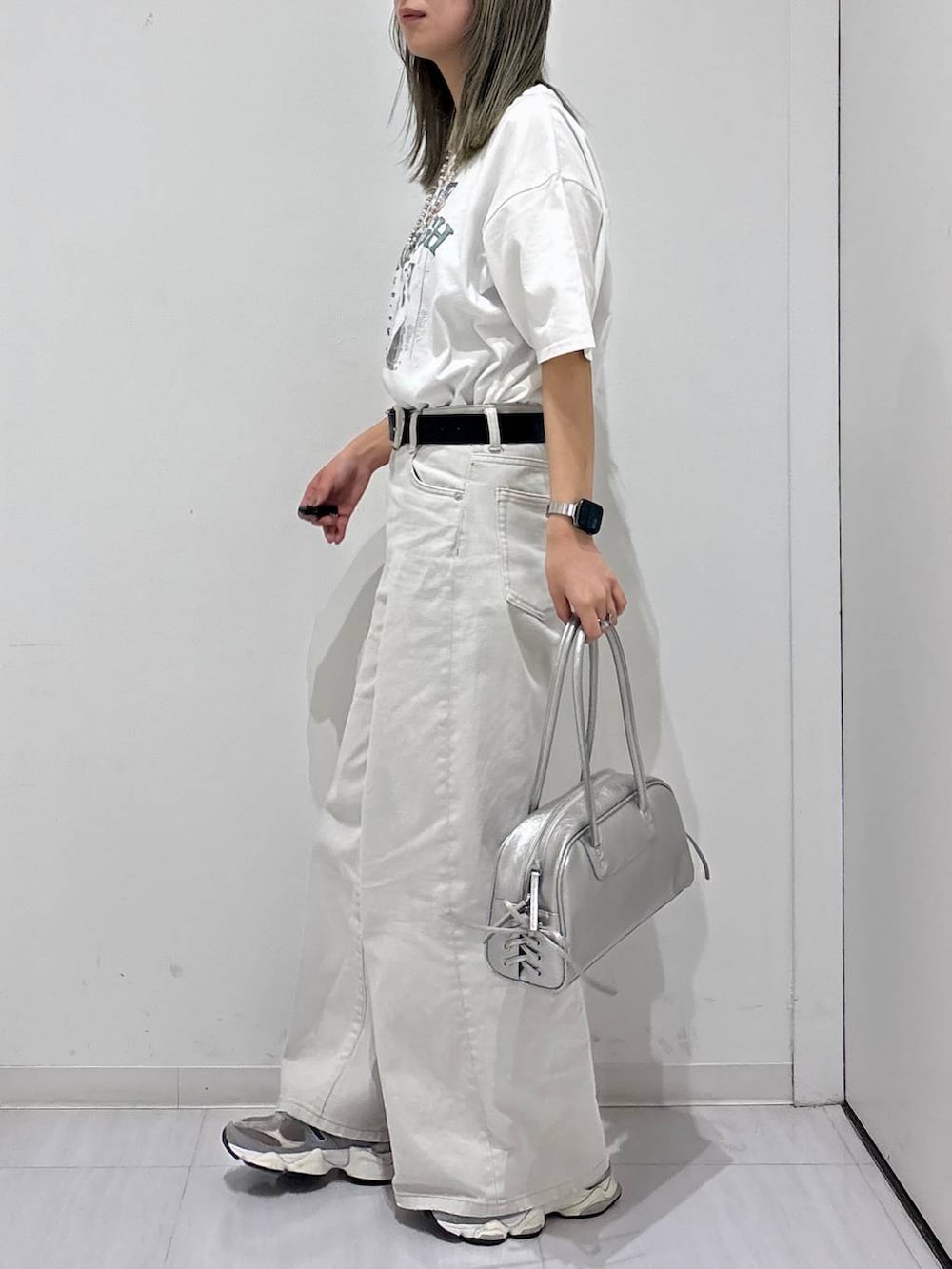グレー系のデニムパンツ、ホワイト系のTシャツ/カットソー、シルバー系のショルダーバッグを着用したレディースの春コーディネートの2枚目の写真