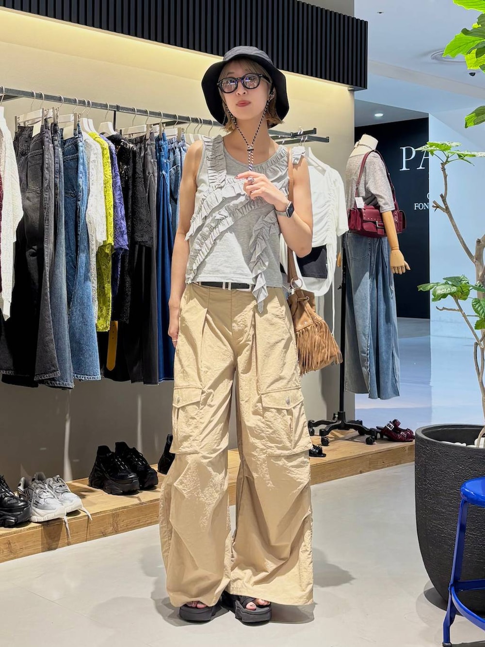 グレー系のタンクトップ、ベージュ系のカーゴパンツ、ブラック系のベルトを着用したレディースの夏コーディネートの2枚目の写真