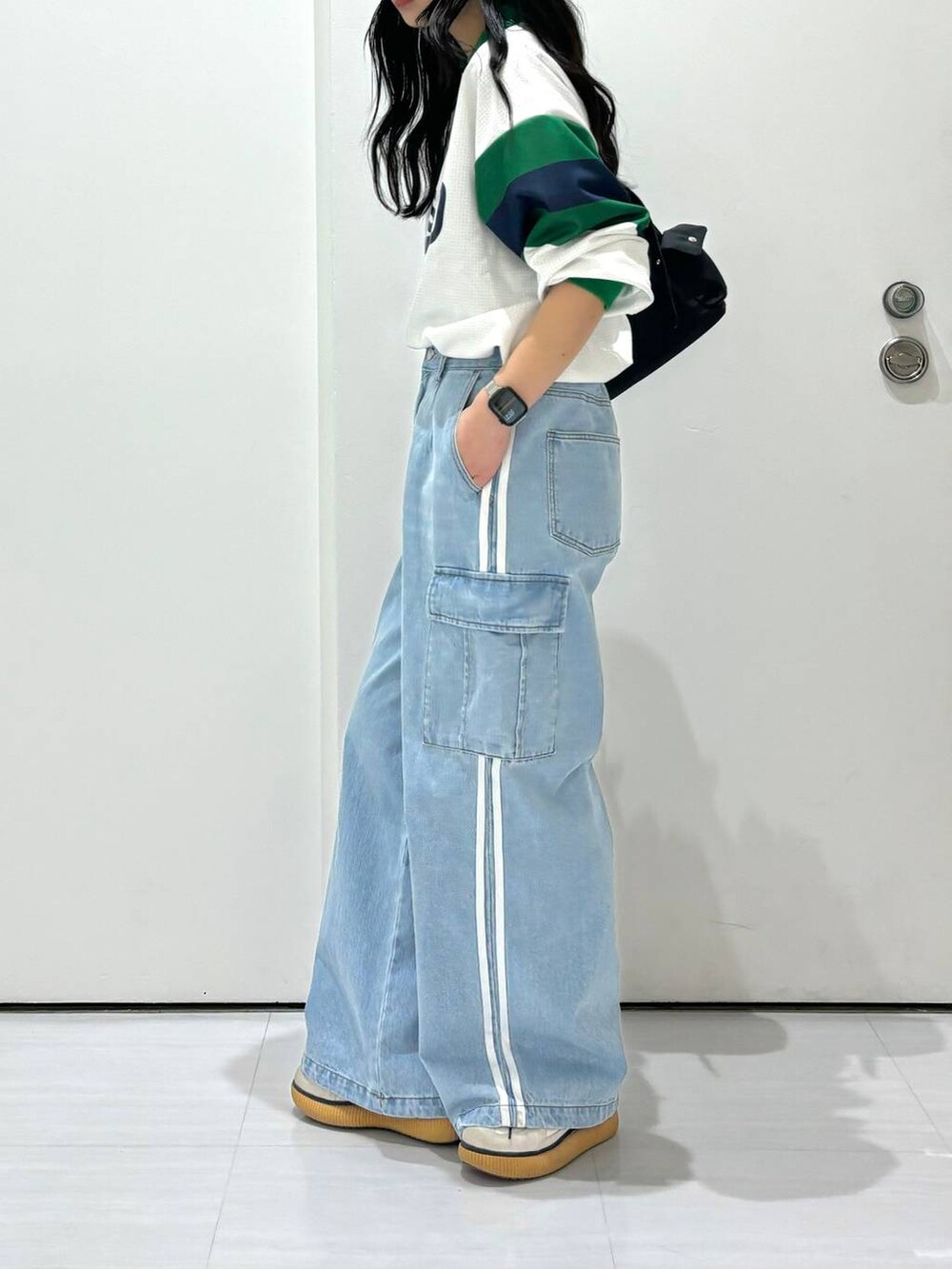 ブラック系のショルダーバッグ、ホワイト系のシャツ/ブラウス、ブルー系のデニムパンツを着用したレディースの春コーディネートの3枚目の写真