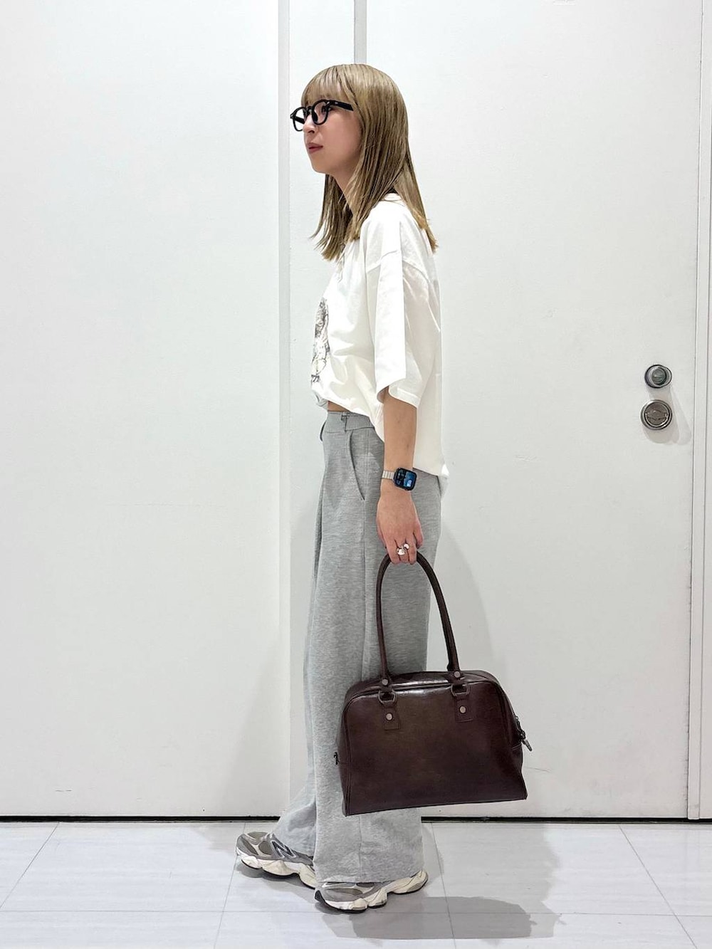 ブラウン系のボストンバッグ、ホワイト系のTシャツ/カットソー、グレー系のスウェットパンツを着用したレディースの春コーディネートの3枚目の写真