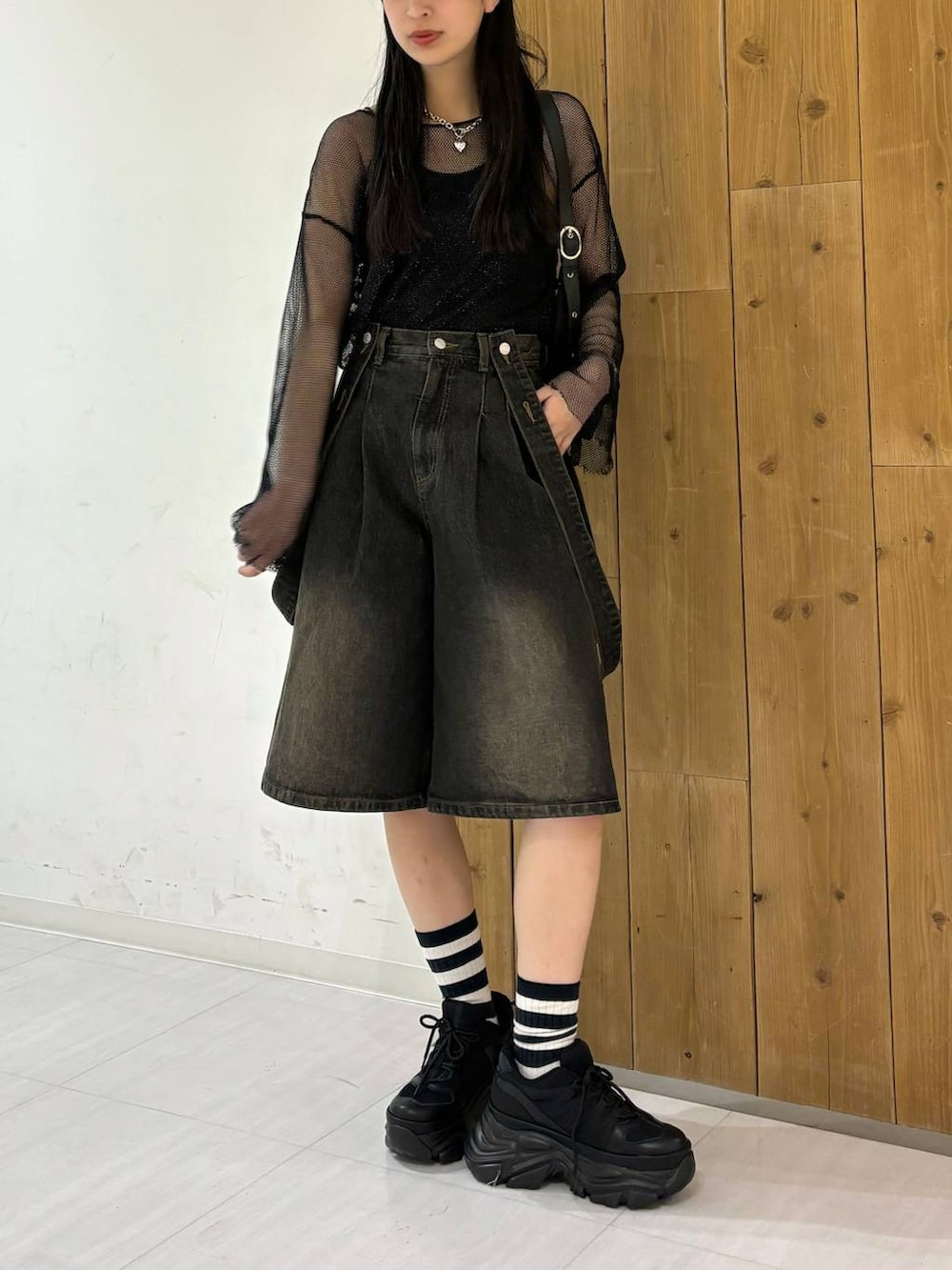 ブラック系のスニーカー、ブラック系のTシャツ/カットソー、ブラック系のデニムパンツを着用したレディースの春コーディネートの6枚目の写真