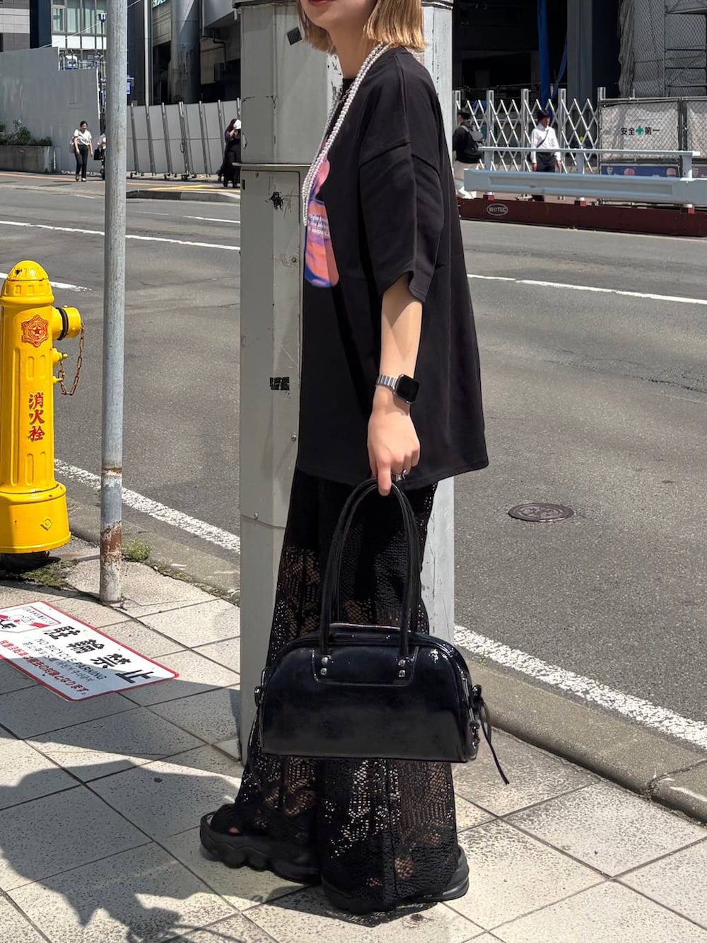 ブラック系のショルダーバッグ、ブラック系のTシャツ/カットソー、ホワイト系のネックレスを着用したレディースの夏コーディネートの4枚目の写真