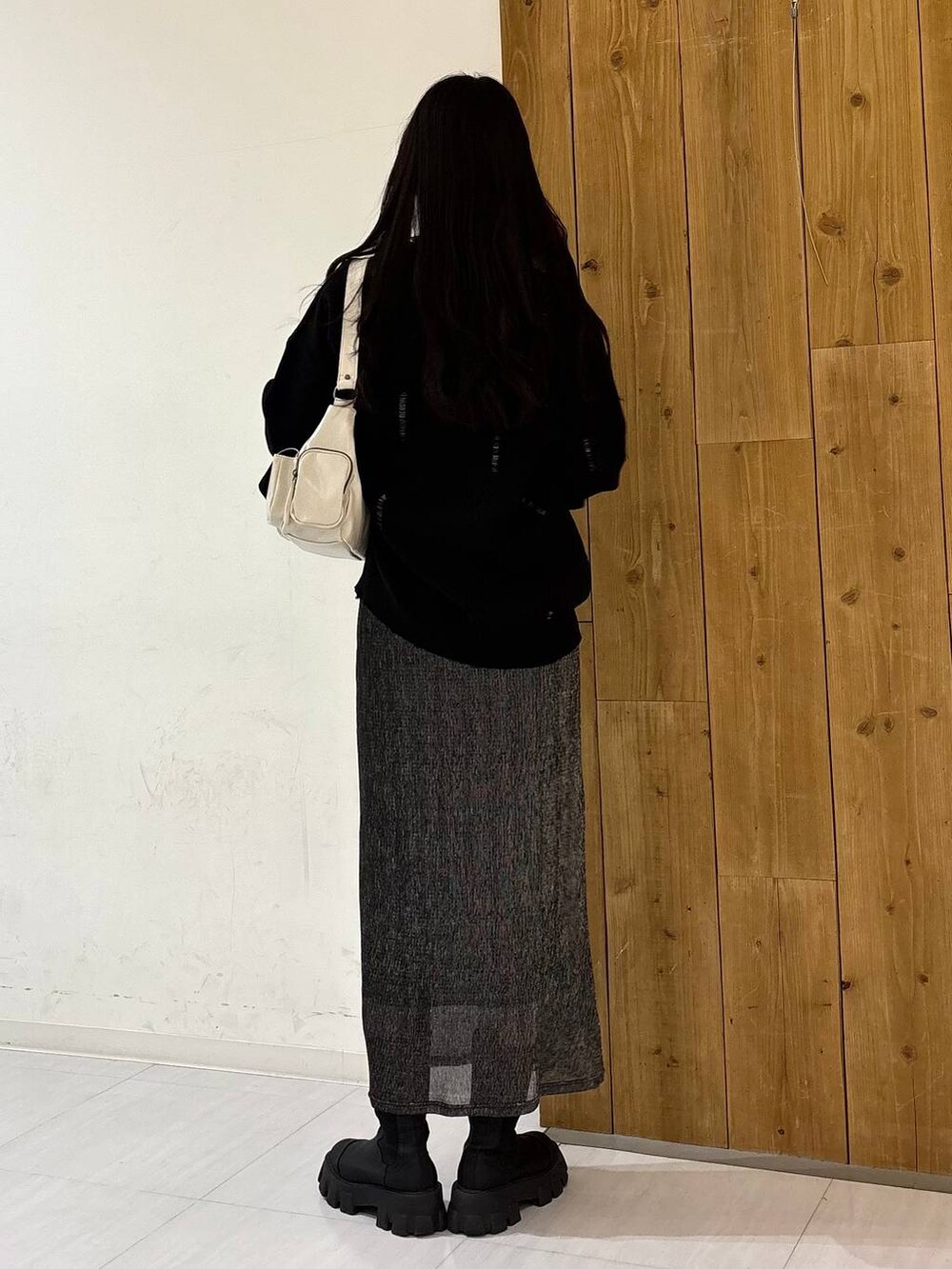 ホワイト系のショルダーバッグ、ブラック系のニット/セーター、ブラック系のスカートを着用したレディースの冬コーディネートの4枚目の写真