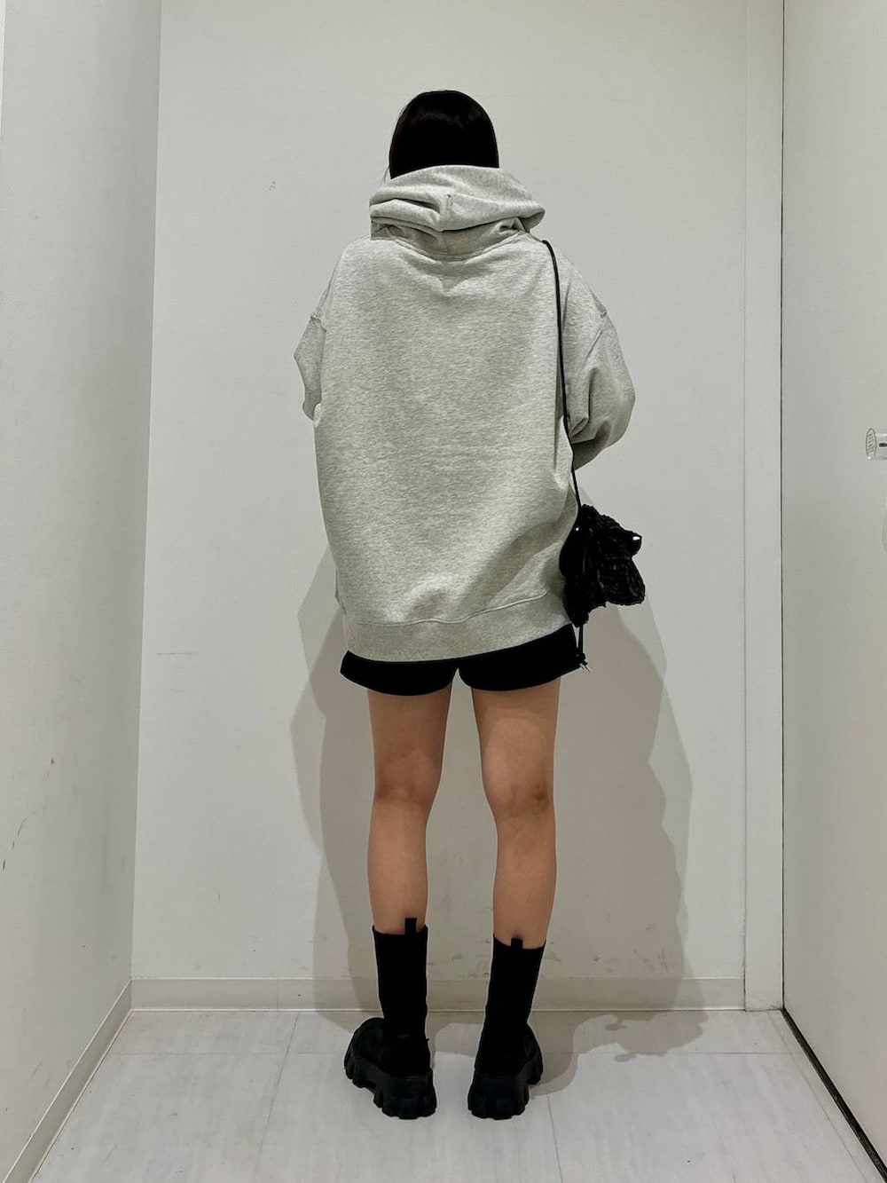 グレー系のパーカー、ブラック系のブーツ、ブラック系のその他パンツを着用したレディースの冬コーディネートの4枚目の写真