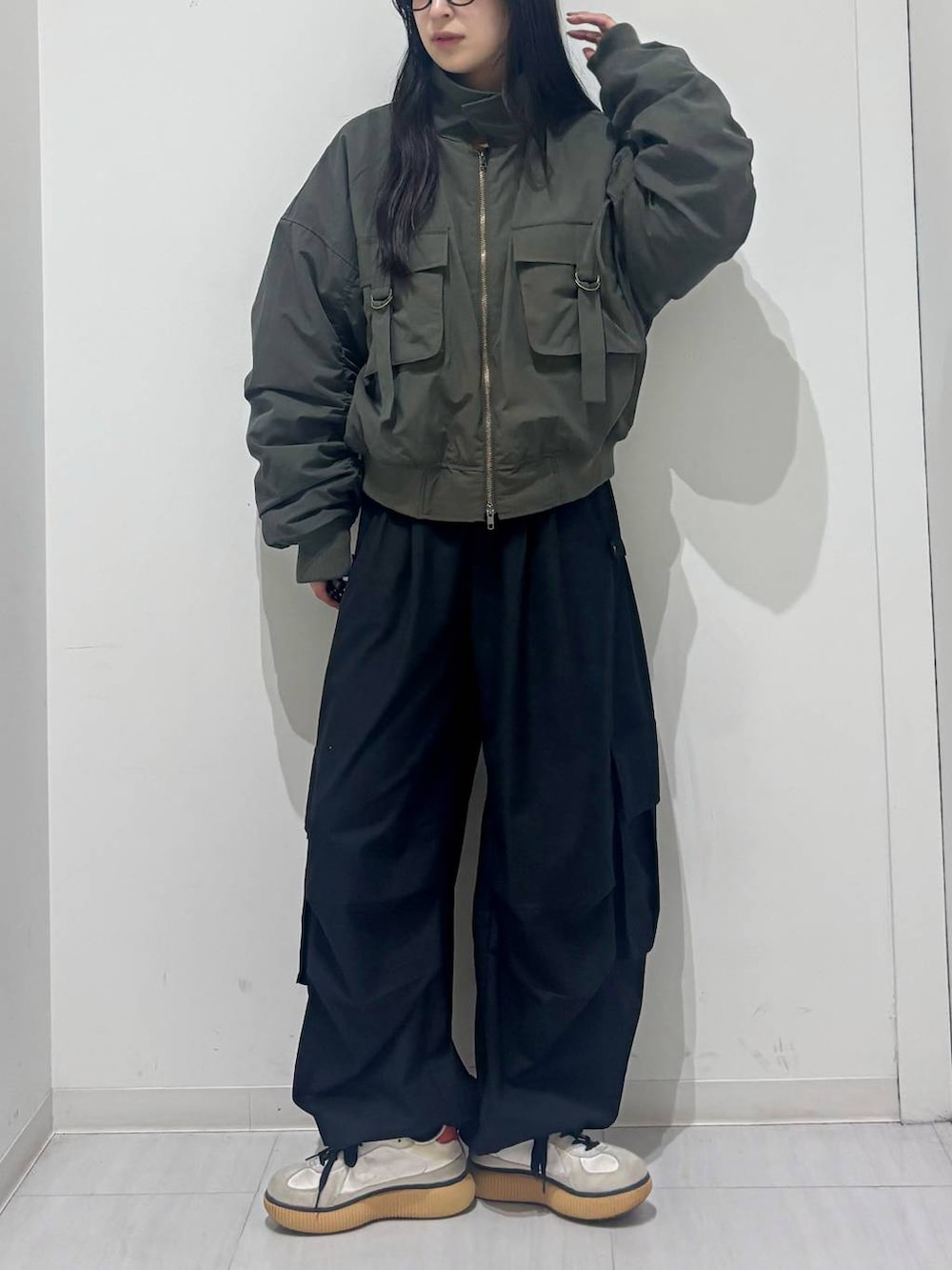 グリーン系のブルゾン、ブラック系のカーゴパンツを着用したレディースの秋コーディネートの2枚目の写真