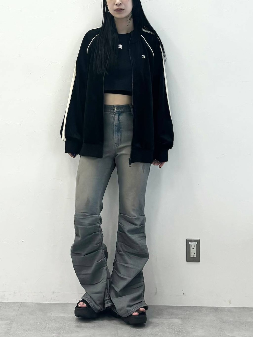 ブルー系のデニムパンツ、ブラック系のジャージを着用したレディースの秋コーディネートの6枚目の写真