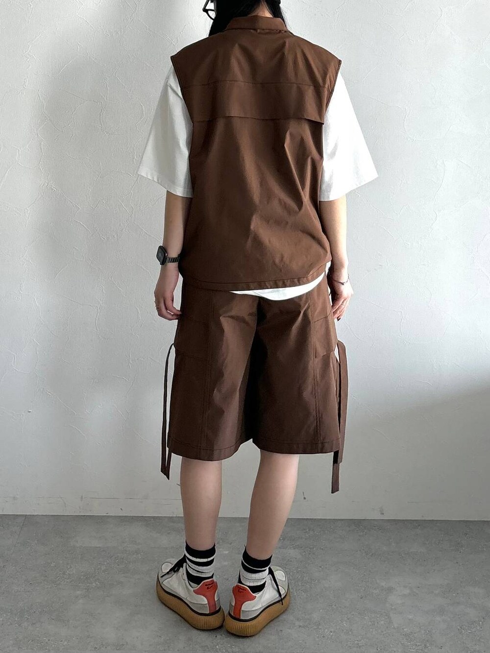 ホワイト系のTシャツ/カットソー、ブラウン系のベスト、ブラウン系のカーゴパンツを着用したレディースの夏コーディネートの4枚目の写真